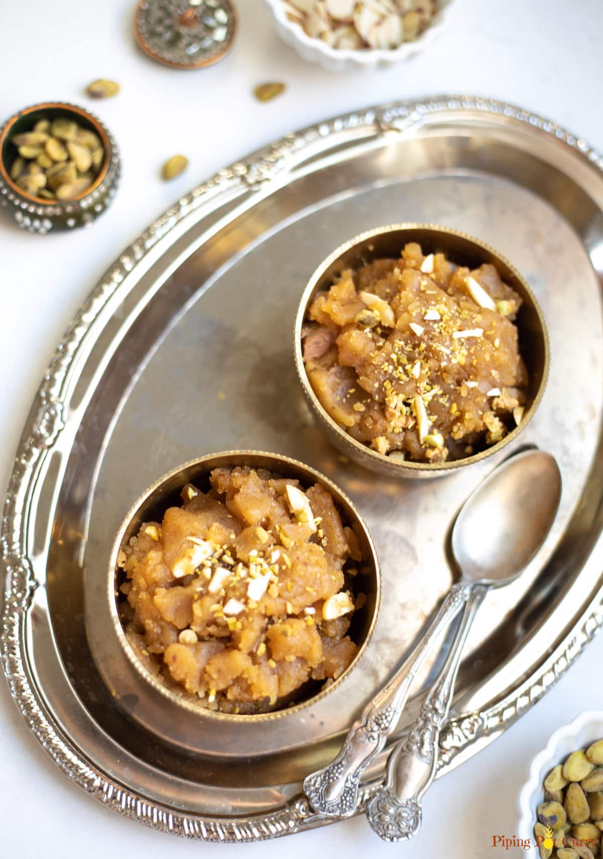Moong Dal Halwa sweet served in 2 bowls topped with chopped nuts