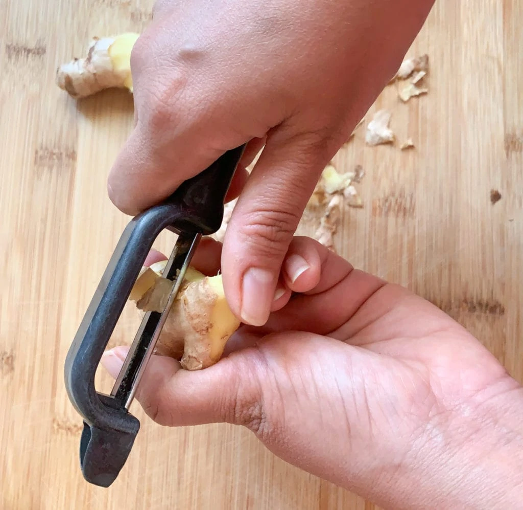 Peeling ginger with a peeler