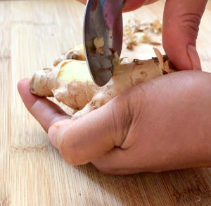 peeling ginger root with the back of a spoon.