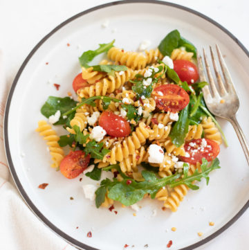 Rotini with arugula and cherry tomatoes topped with feta