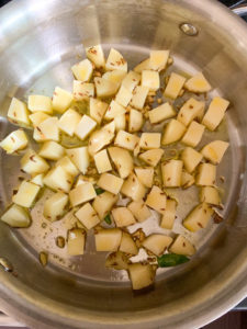 Potatoes being cooked in a heavy bottom pan
