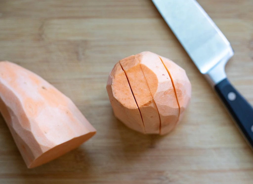 cutting sweet potato in a chopping board