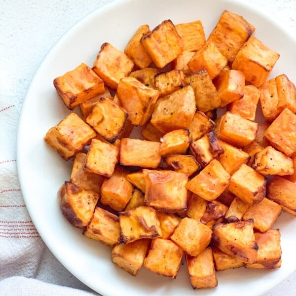 Roasted sweet potato pieces in a white plate