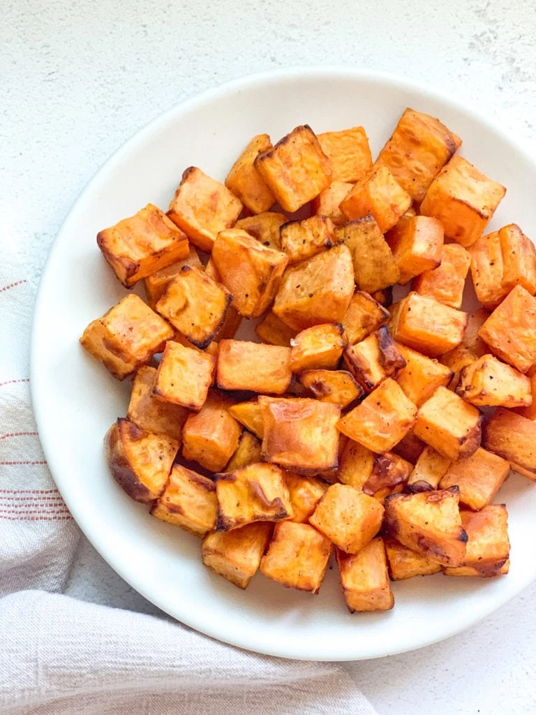 Roasted sweet potato pieces in a white plate