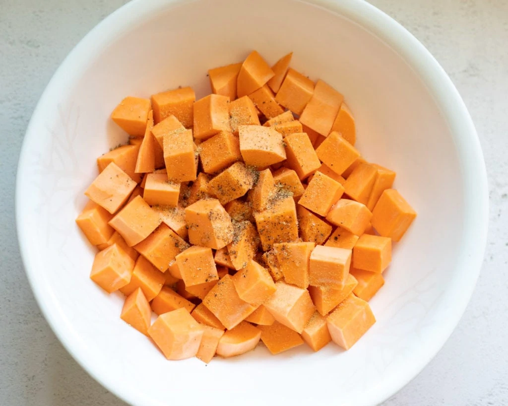 Spices and olive oil on sweet potato chunks