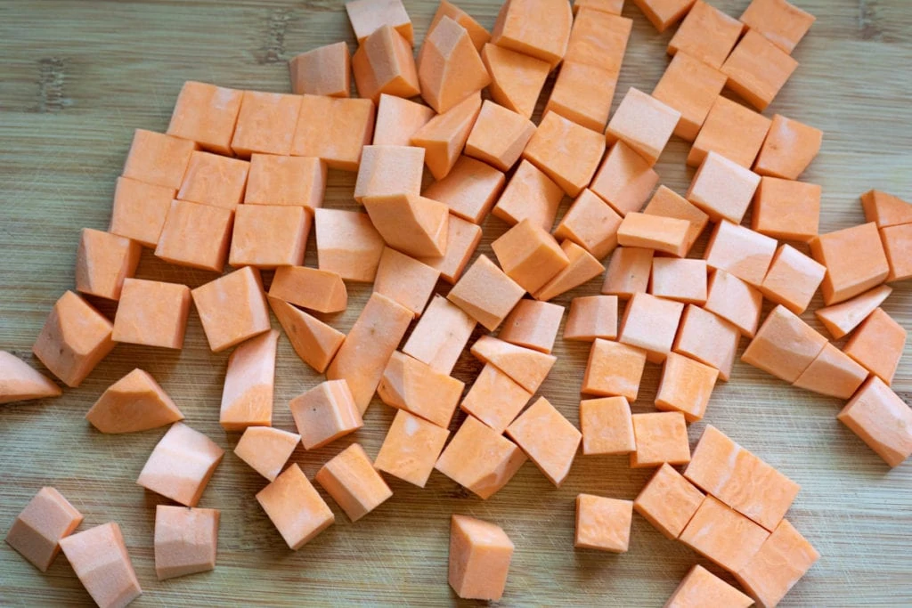 Sweet potatoes cut into cubes on a cutting board