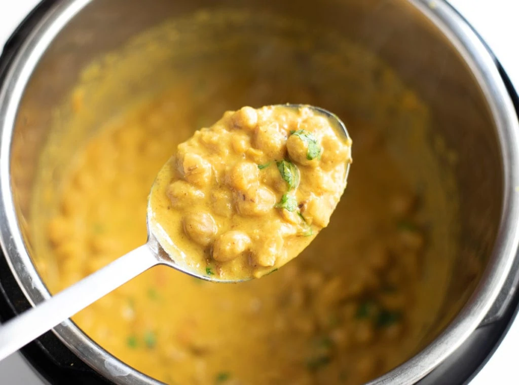 Coconut chickpea curry in a ladle over the instant pot
