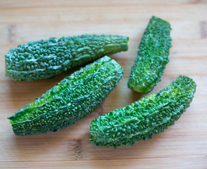 Karela, also called bitter melon on a wooden cutting board