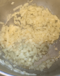 onion and garlic being sautéed in a pot