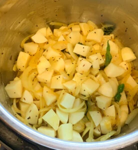 Potato, onion and spices in the instant pot ready to be cooked