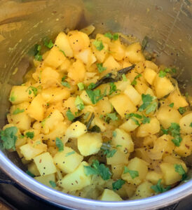 Cooked potato masala garnished with cilantro in the instant pot