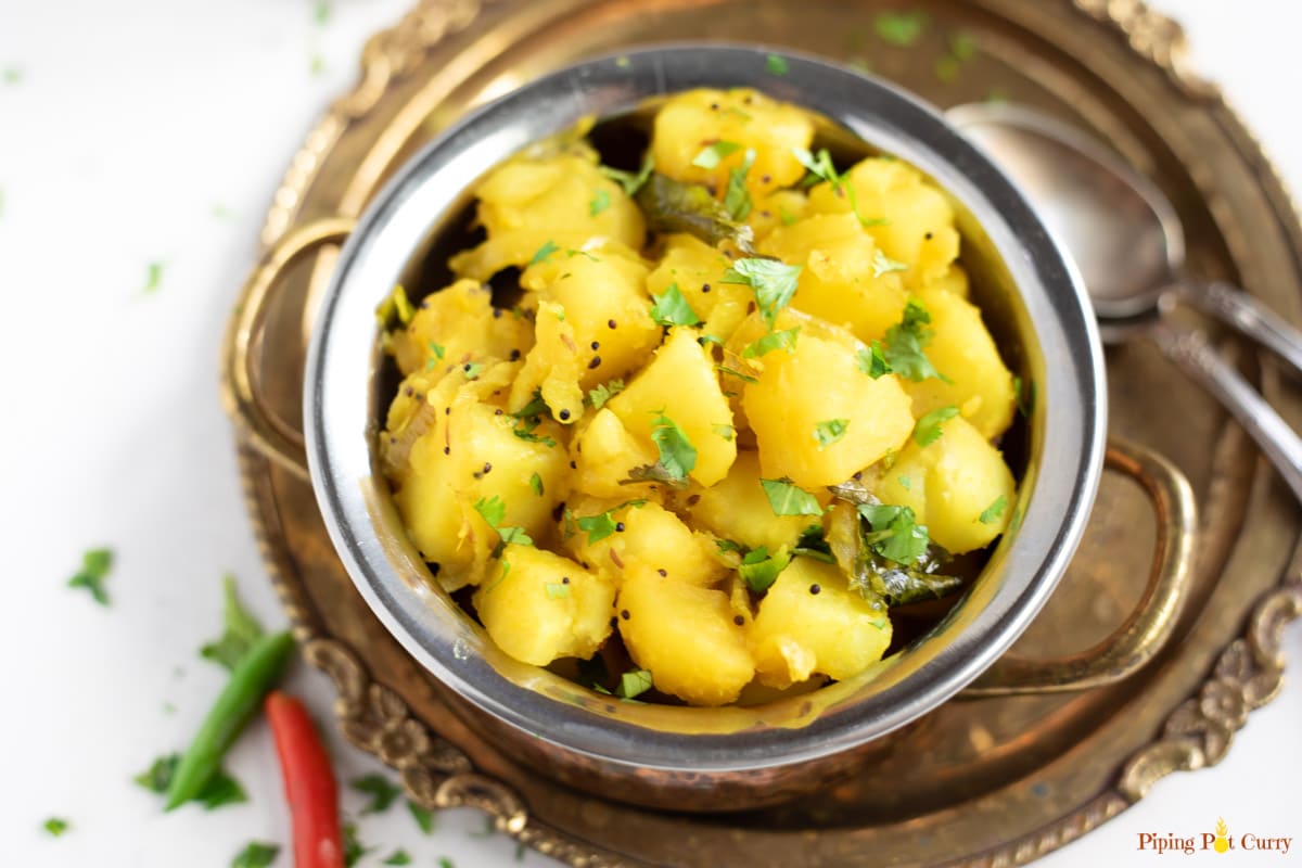 Potato bhaji in a small bowl garnished with coriander