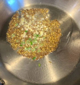 tempering spices such as cumin, ginger and green chili in oil