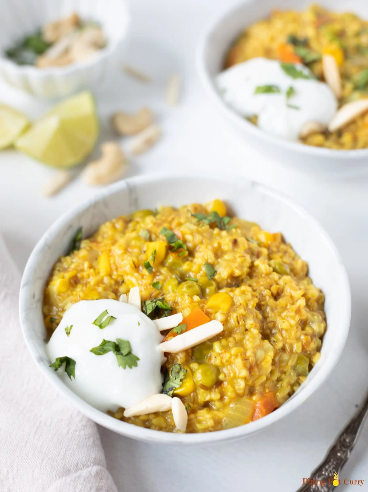 Savory oatmeal with veggies and spices in a bowl along with yogurt