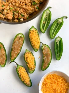Jalapeños being Stuffed with spiced potatoes topped with grated cheese