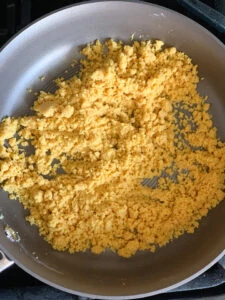 Besan (gram flour) mixed with ghee in a pan