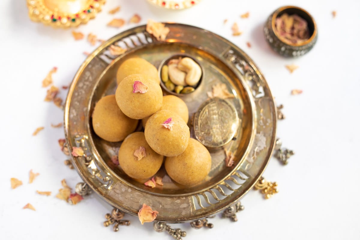 Besan Ladoo in a pretty plate topped with dried rose petals 