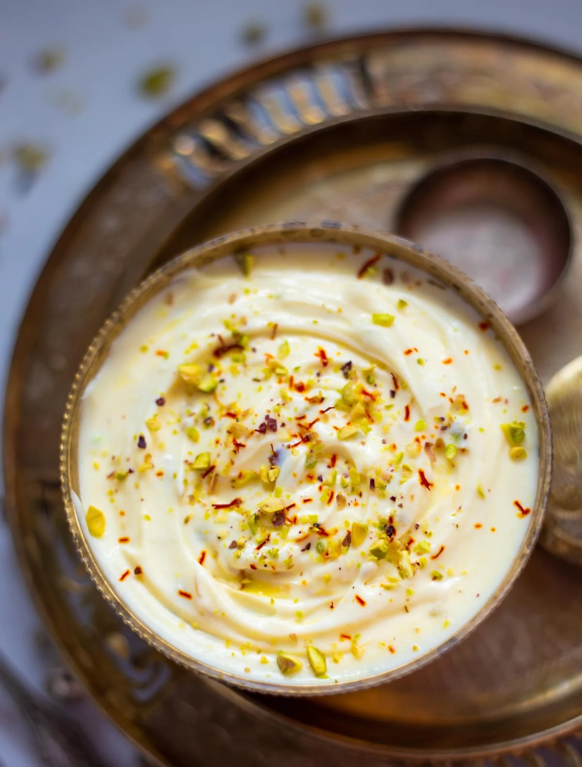 Shrikhand in a pretty bowl garnished with saffron and pistachios - Kesar Pista shrikhand