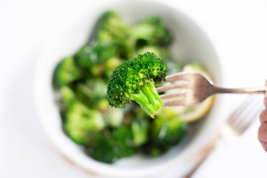 Closeup of roasted broccoli in a fork