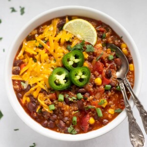 vegetarian quinoa chili topped with cheese, jalapeños and lime