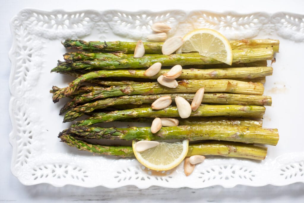 roasted asparagus with lemon wedges and blanched almonds