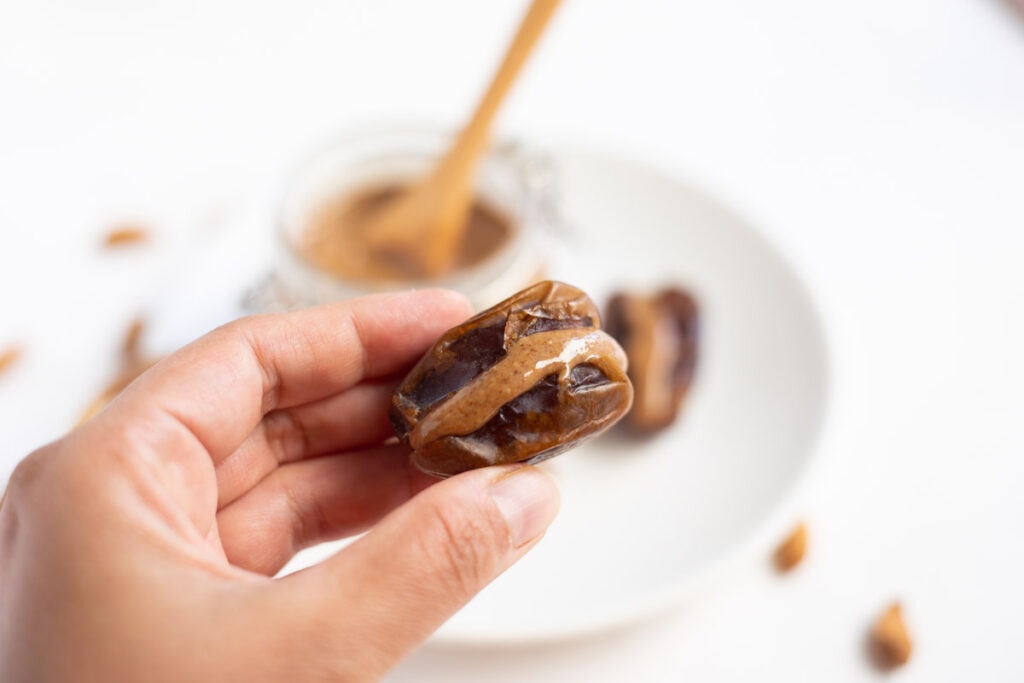Mejdool date stuffed with almond butter in hand 