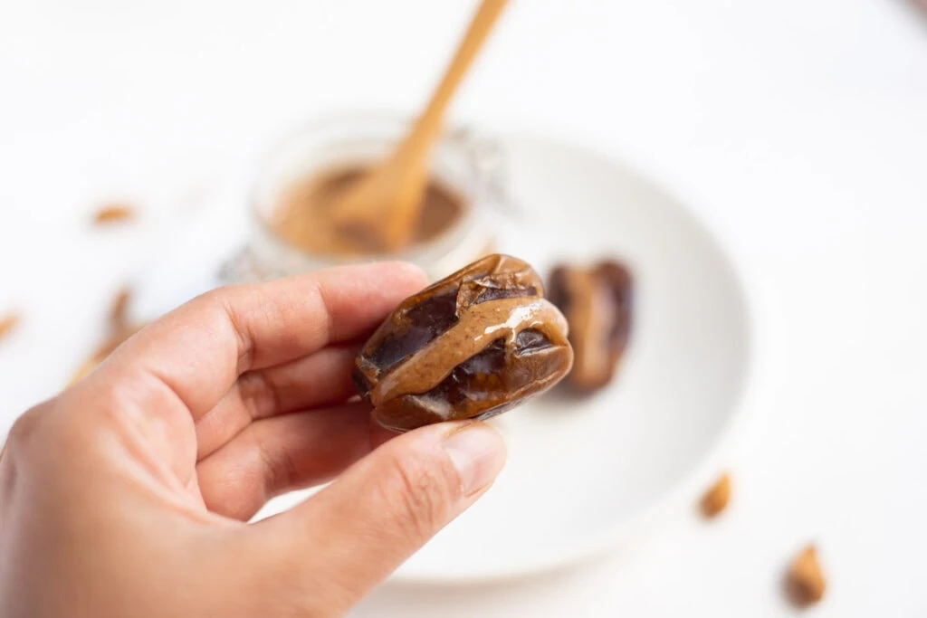 Mejdool date stuffed with almond butter in hand