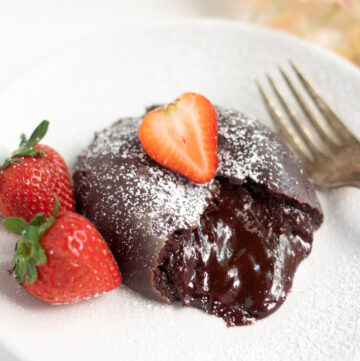 chocolate lava cake with chocolate flowing and strawberry in the top and side