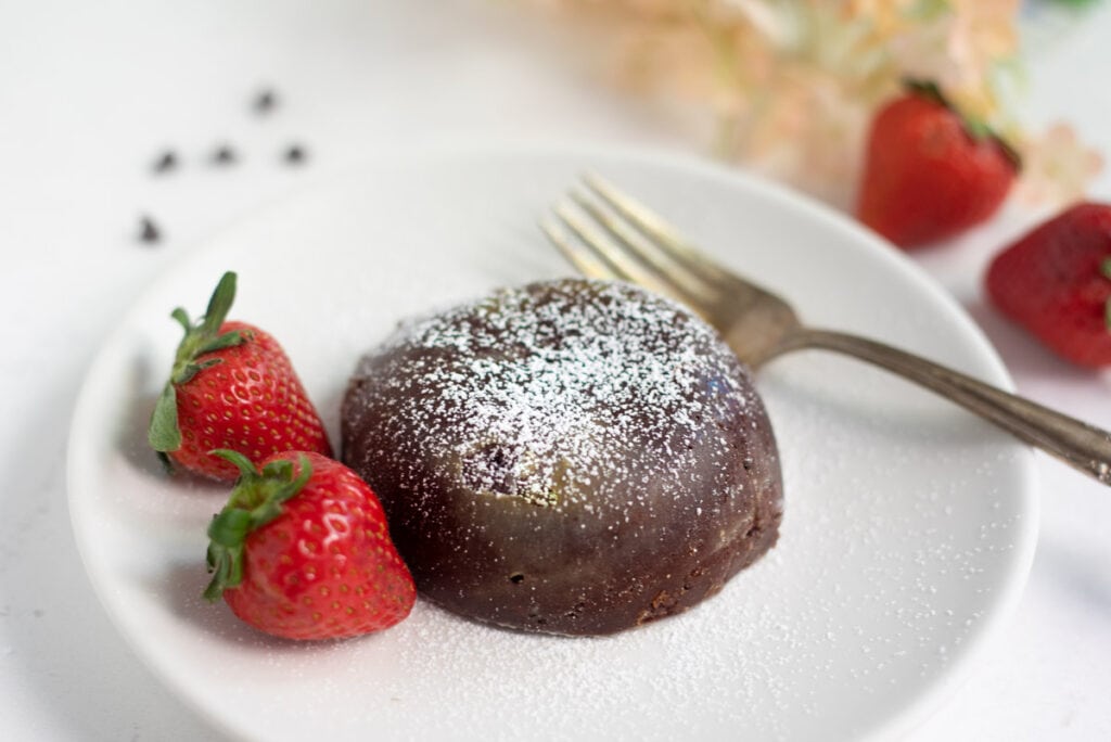 Molten chocolate lava cake with strawberries on a while plate 
