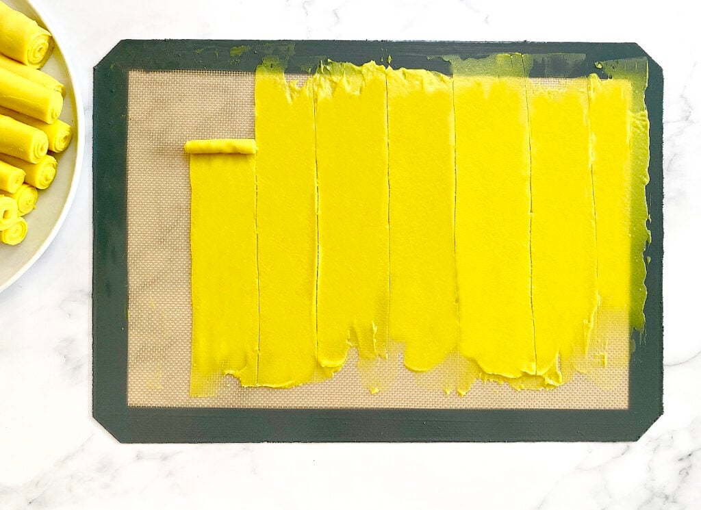 rolling khandvi batter in a silicon mat