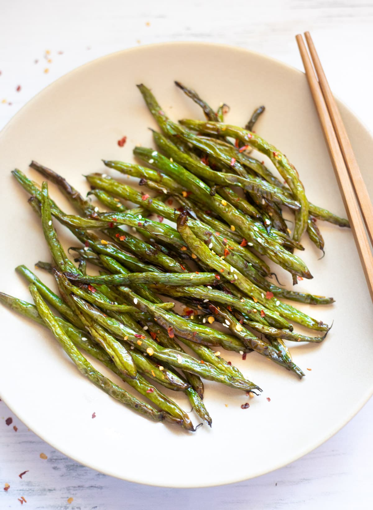 Chinese style roasted green beans with garlic on a plate with chopsticks