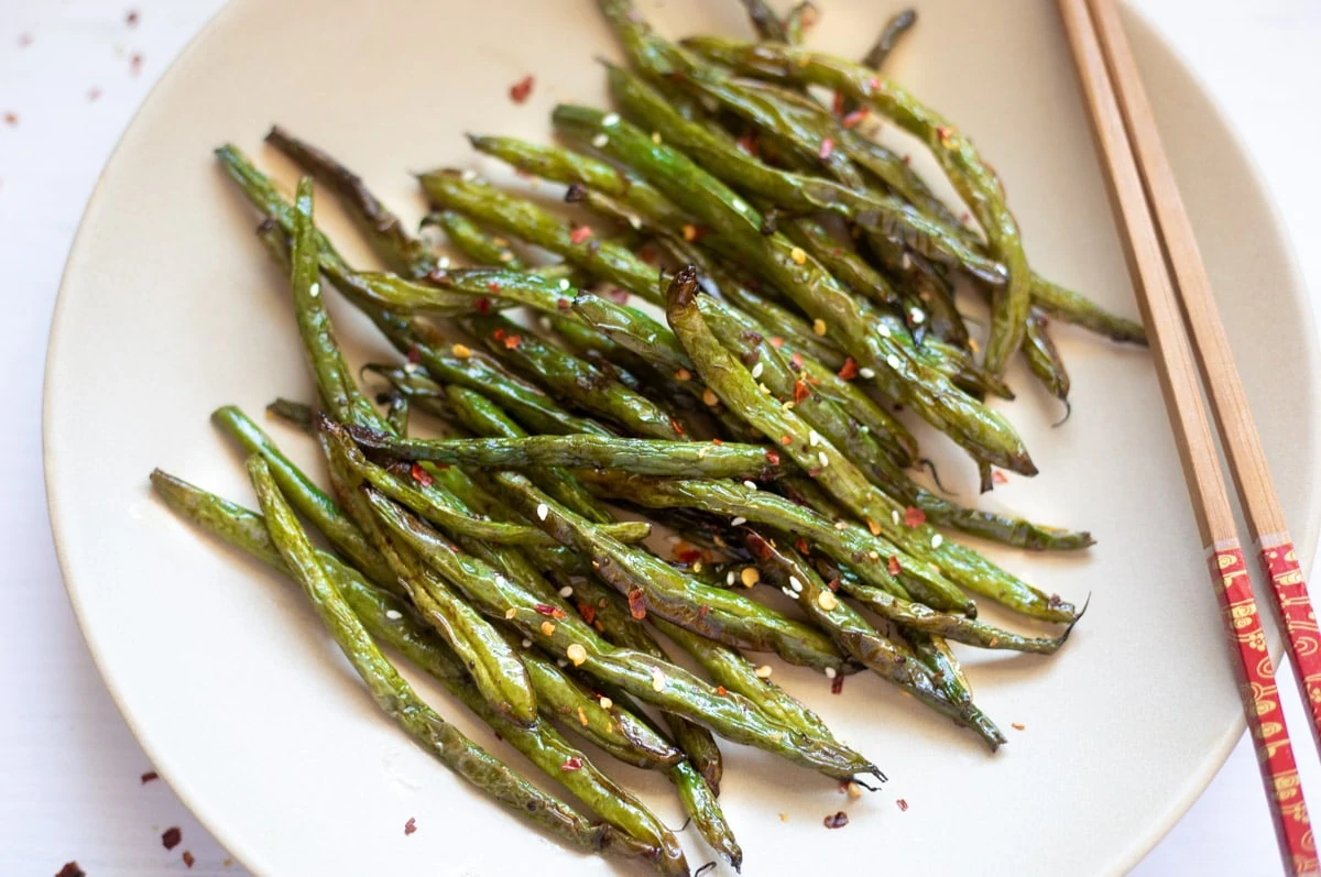 Roasted garlic green beans in a plate with chopsticks