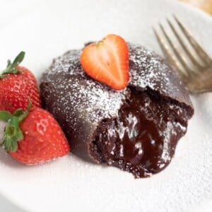 molten lava cake with chocolate flowing and strawberry in the top and side