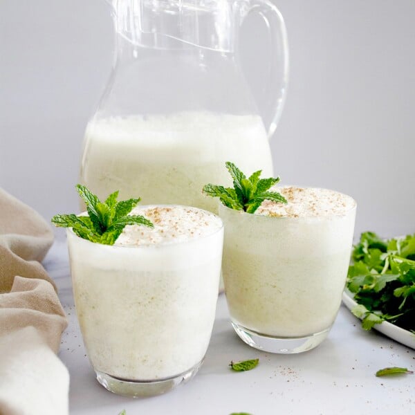Indian Buttermilk Chaas in 2 glasses and a jug garnished with mint leaves