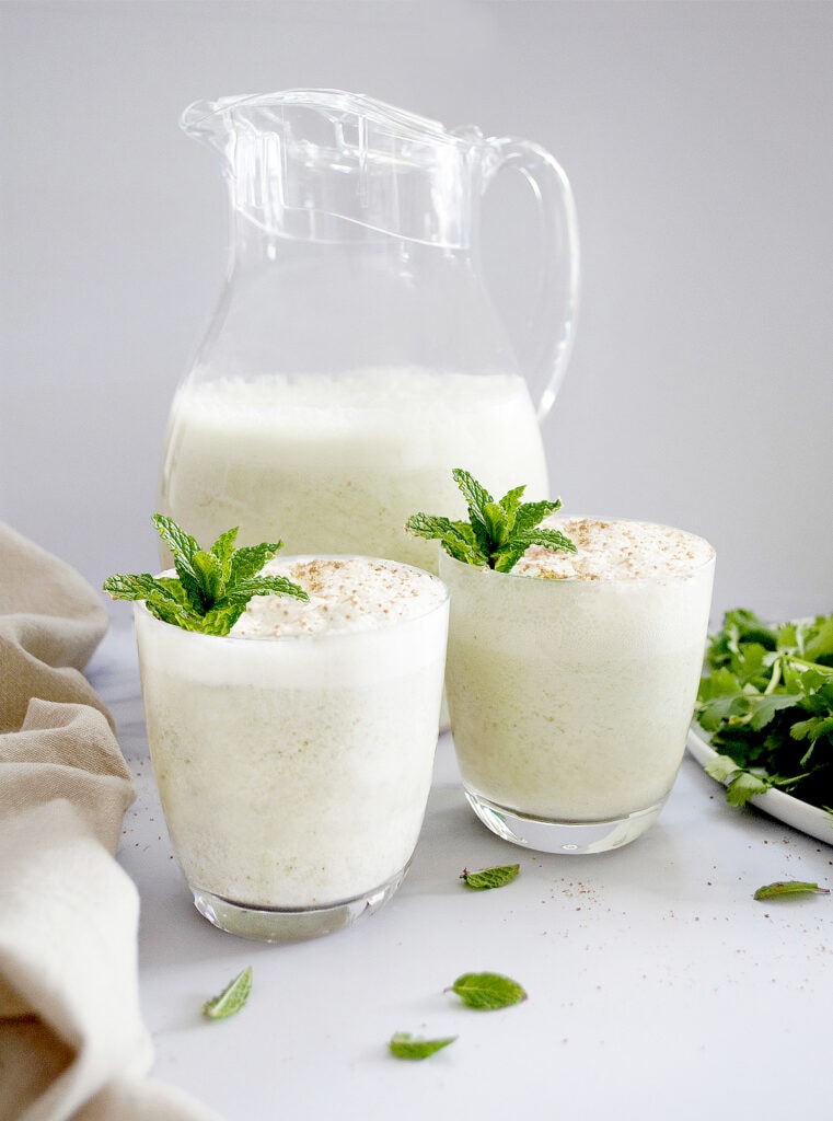 Indian Buttermilk Chaas in 2 glasses and a jug garnished with mint leaves