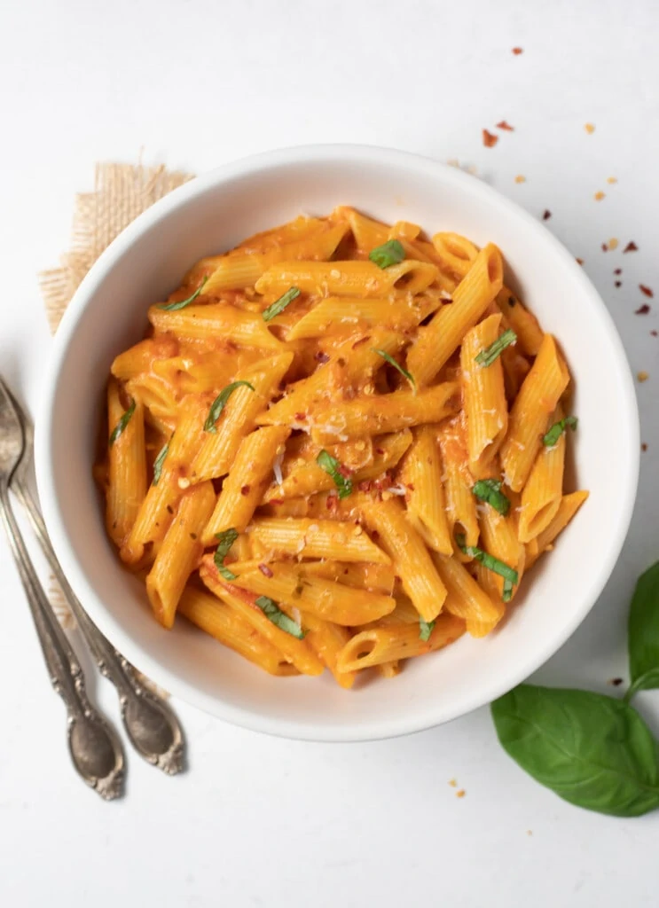 Creamy Penne Pasta topped with basil, parmesan and chili flakes 