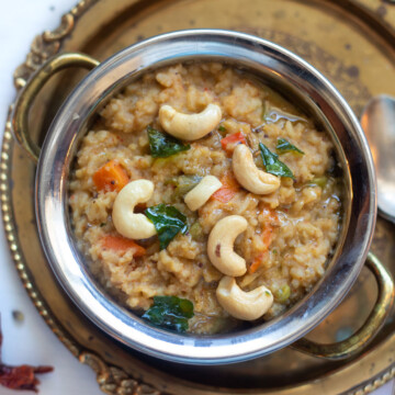 Bisi Bele Bath - How Spicy lentils and rice in a pretty bowl garnished with tempering and cashews.