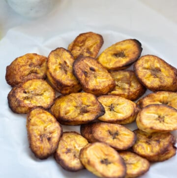 air fried plantains served in a plate over parchment paper
