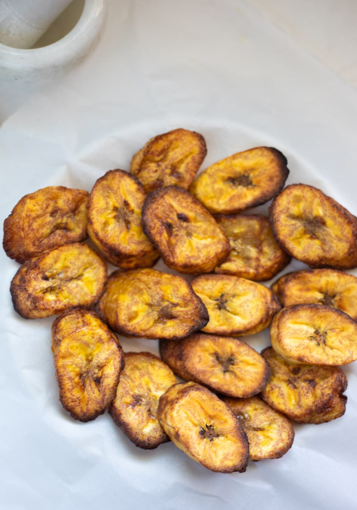 Healthy Fried Plantains served in a plate over parchment paper