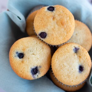 Moist Almond Flour Blueberry Muffins in a basket lined with cloth