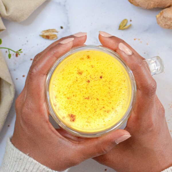A cup of Turmeric Golden Milk in hand