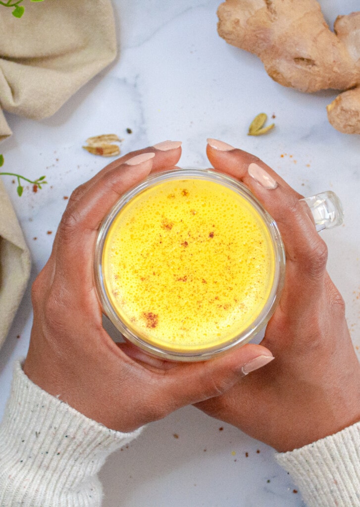 A cup of Turmeric Golden Milk in hand