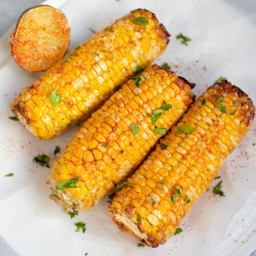 Spicy grilled corn on the Cobb in a plate with a lime