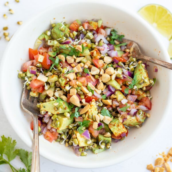 Sprouted beans salad in a bowl topped with chopped peanuts.