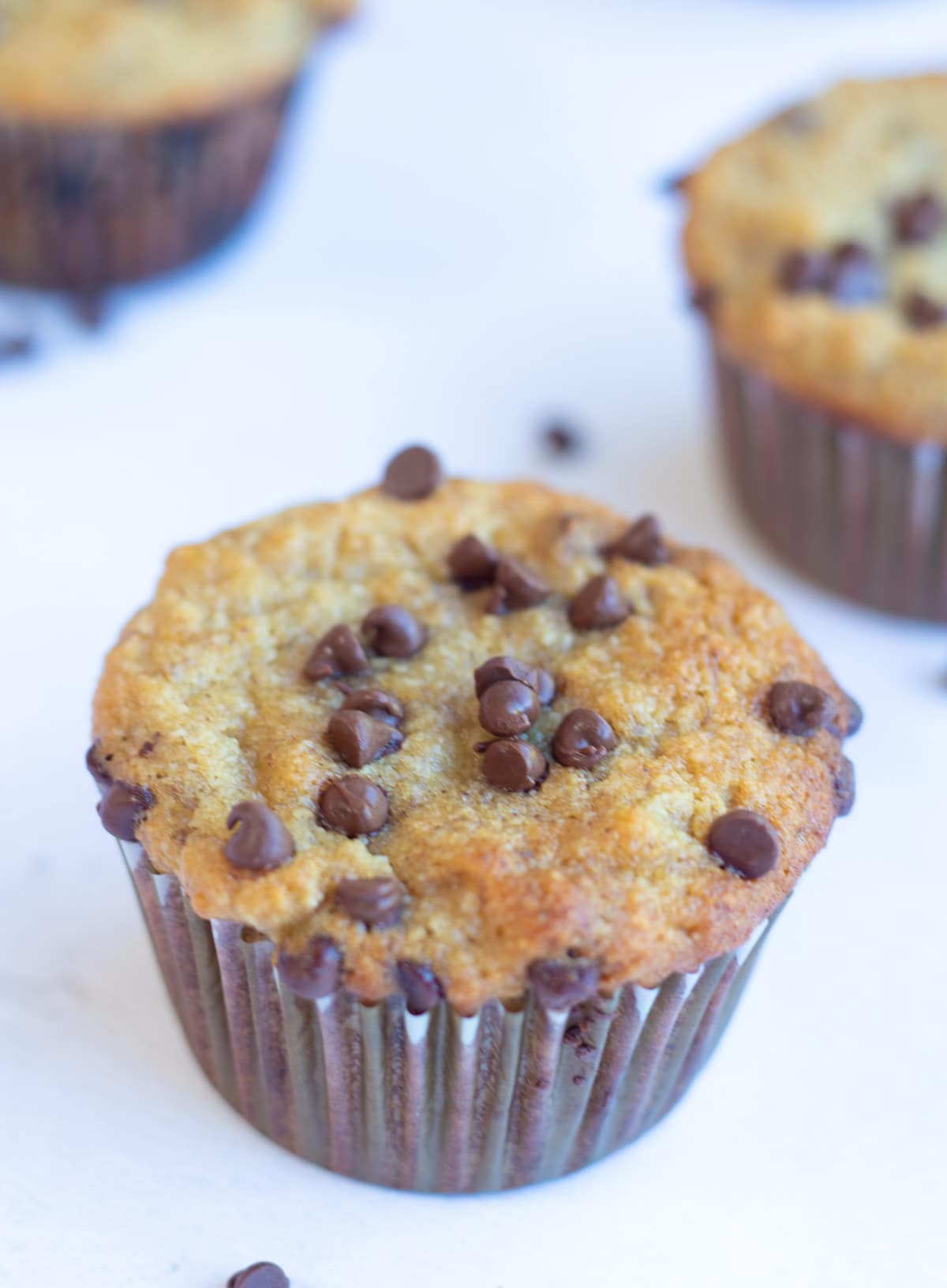 Banana chocolate chip muffins on a white table