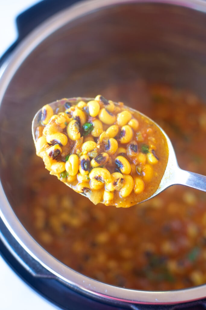 black eyed peas curry, lobia in a ladle over the pressure cooker