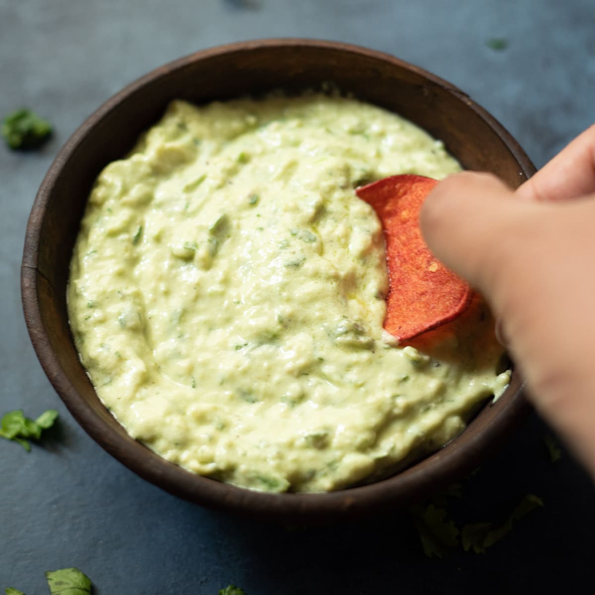 Dipping a chip in Avocado cilantro jalapeno crema sauce