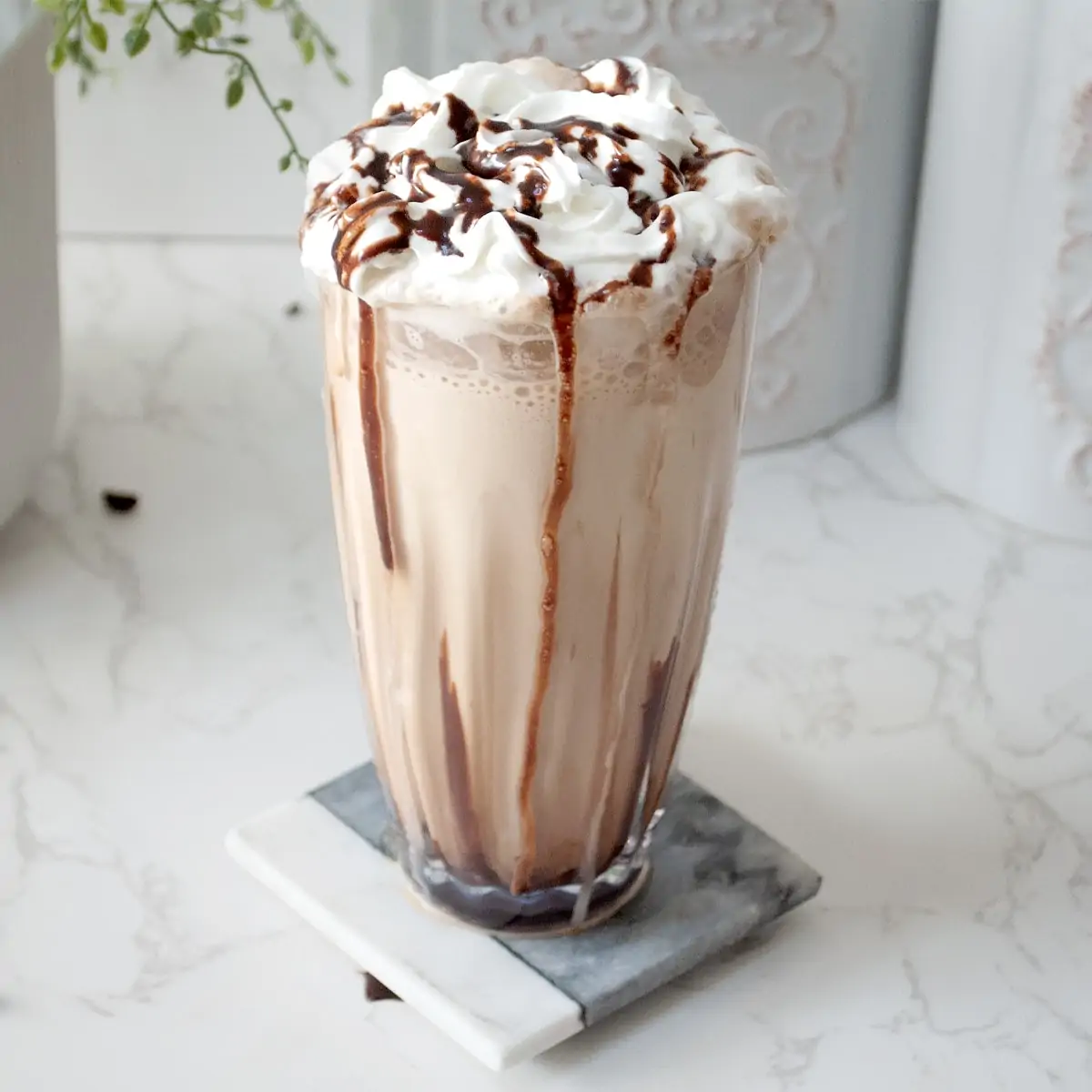 Iced coffee in a glass topped with whipped cream