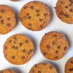 Lots of pumpkin muffins made with almond flour and chocolate chips on a table