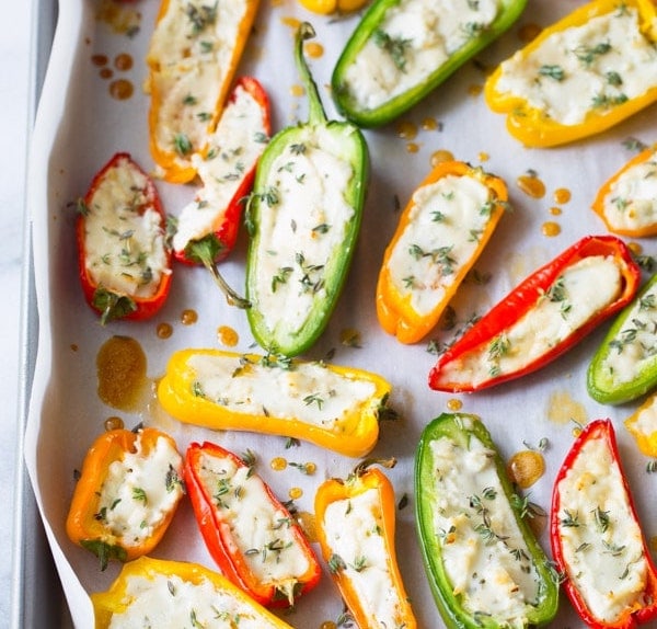 mini stuffed peppers in a baking sheet garnished with fresh herbs